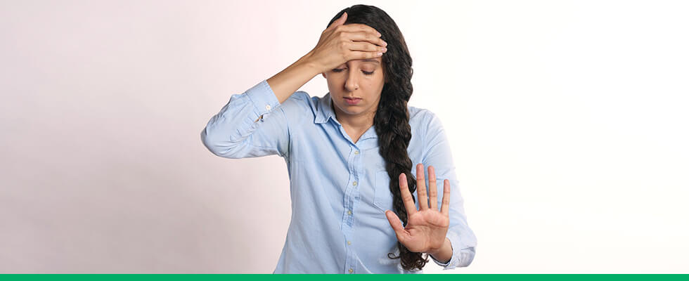 Mulher com dor de cabeça causada pelo período menstrual.