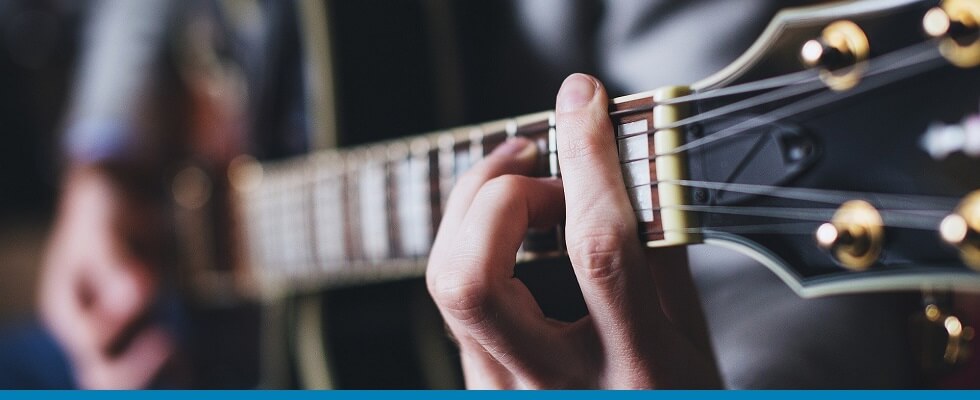 Pessoa tocando guitarra Strinberg