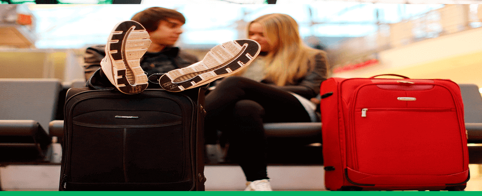 Casal no aeroporto esperando despache de bagagem